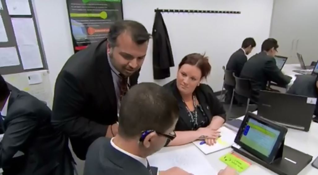 hearing-impaired student working with a class teacher, a TA and a tablet