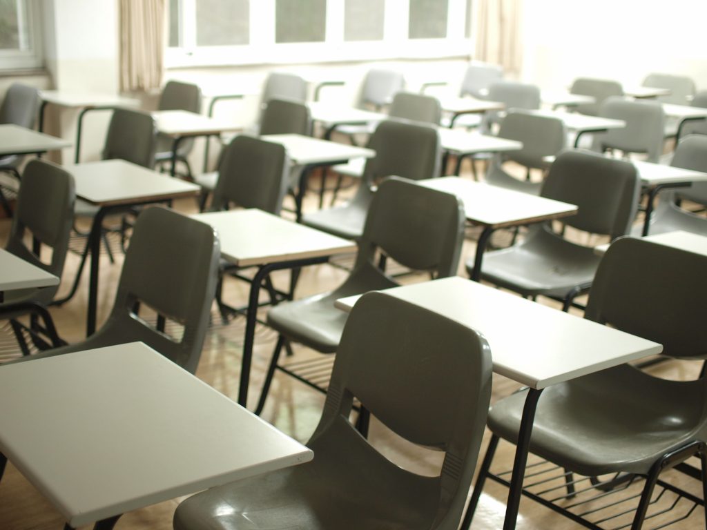 Photo shows desks and tables set out for an exam